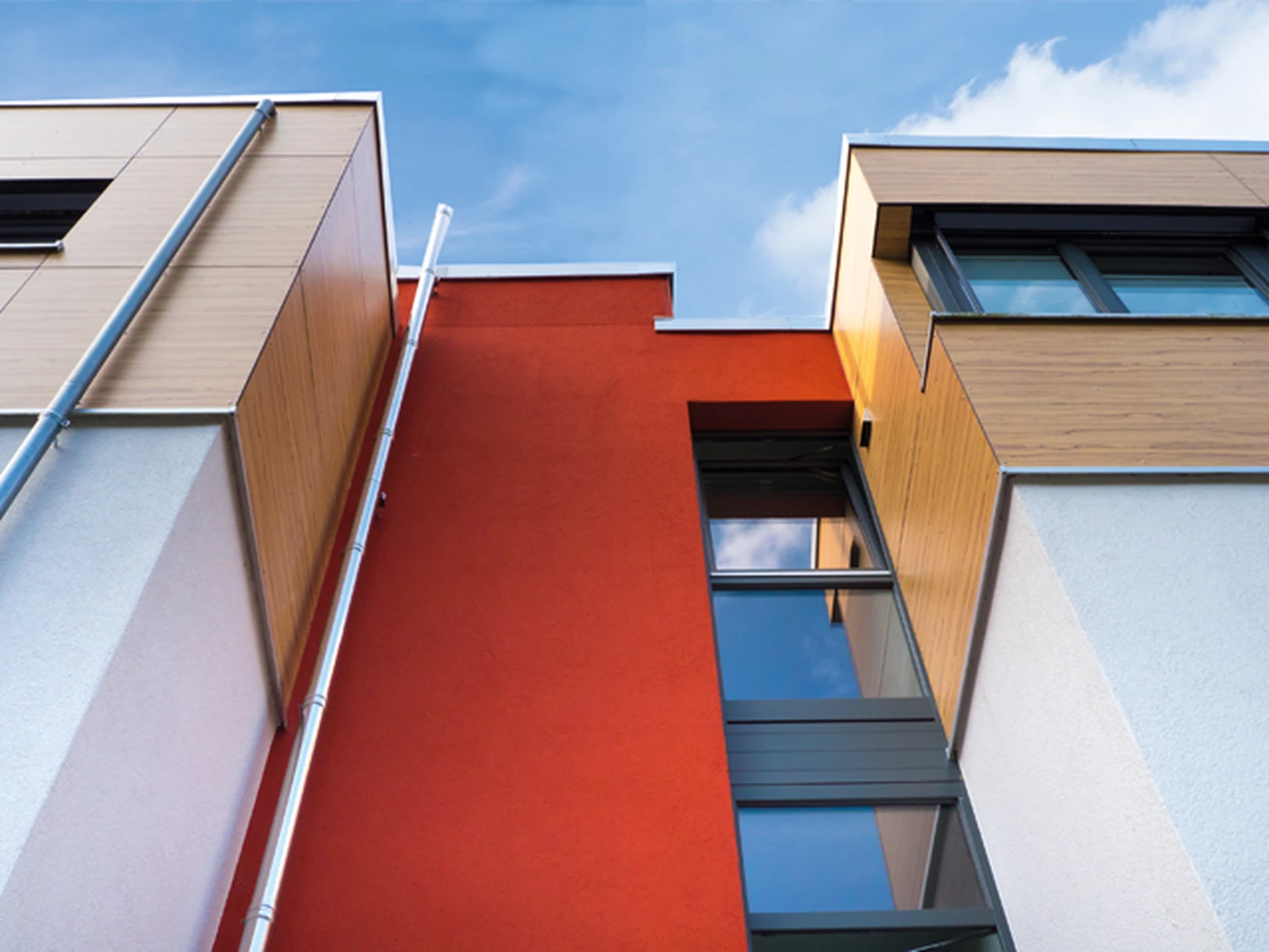 Moderne Fassade mit Holzverkleidung und farbigem Putz